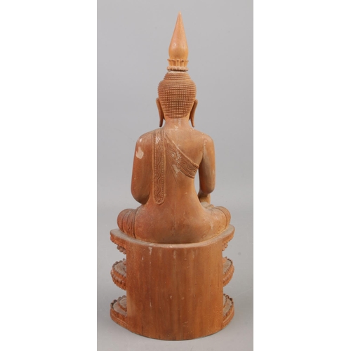 231 - A carved wooden figure of a seated Buddha. 31.5cm.