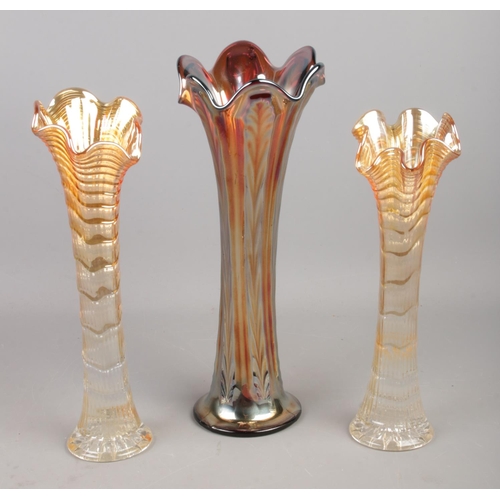 245 - Three ripple carnival glass vases, of varying height. Largest: 30cm high.