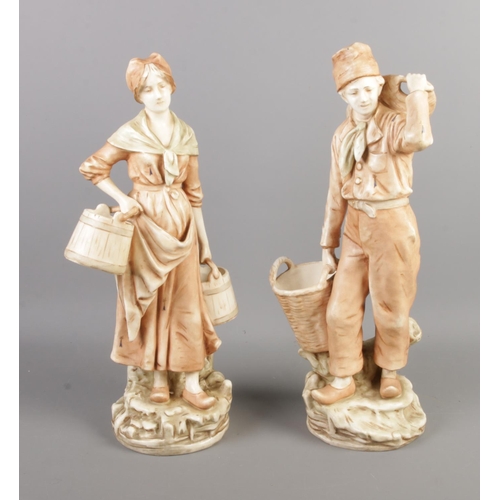 43 - A large pair of Royal Dux style figures depicting a male and female workers carrying baskets. 42cm.