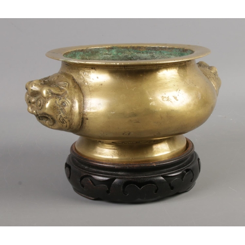 48 - An oriental style, possibly Chinese, brass censor on stand featuring animal head twin handles.