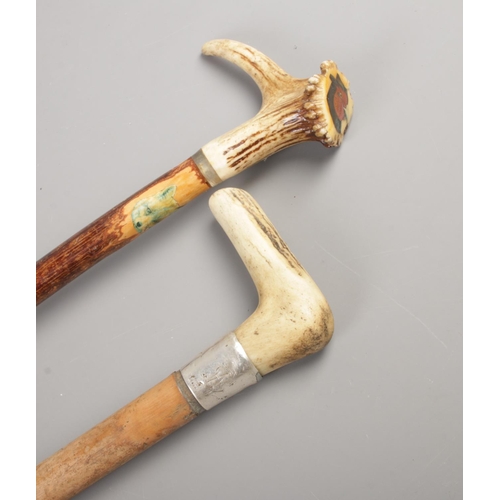 92 - Two carved bone handled walking sticks, one featuring engraved sterling silver cuff.