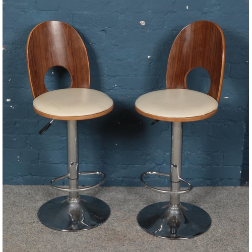 537 - A pair of swivel bar chairs with wooden backs and chrome supports.