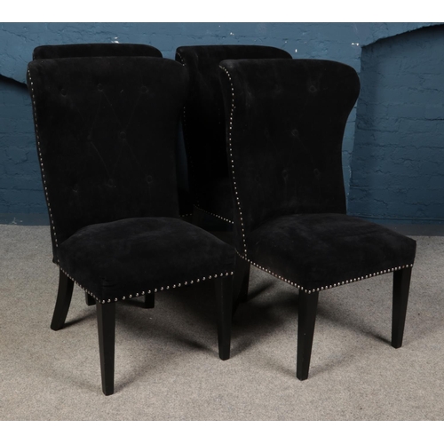 543 - Four black button back dining chairs with studded edges and lion pull handle detail.