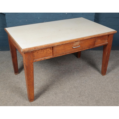 544 - An oak kitchen table with Formica top and drawer to one side. (76cm x 136cm x 83cm)