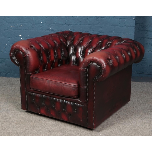 553 - A deep buttoned oxblood leather Chesterfield style arm chair.