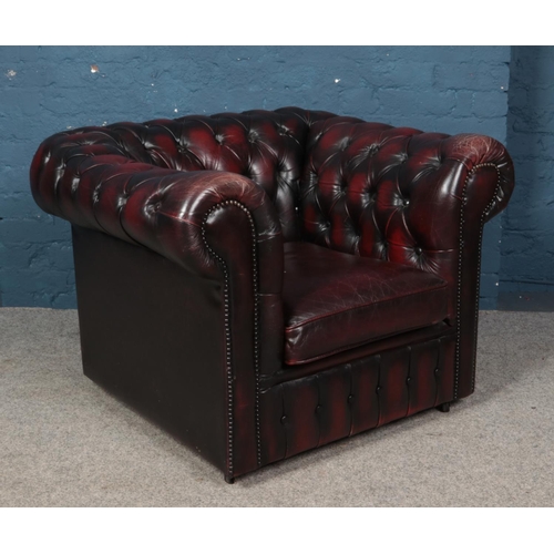 554 - A deep buttoned oxblood leather Chesterfield style arm chair.