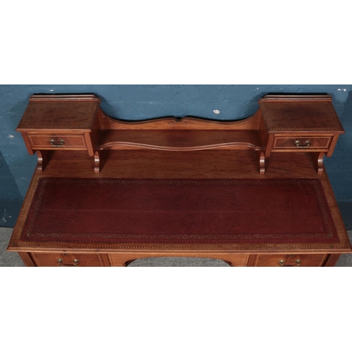 559 - An Edwardian carved mahogany desk with leather inset top. Raised on slender tapering legs. (107cm x ... 