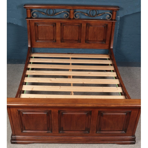 563 - A panelled hardwood & metal double bed. (219cm x 173cm)