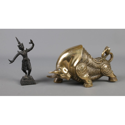 11 - A small bronze figure of a dancer along with oriental style brass charging bull.