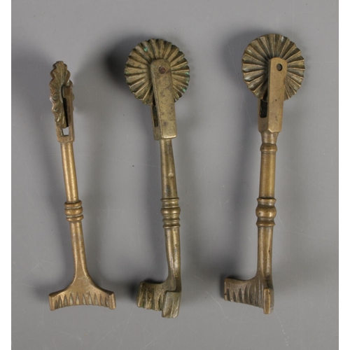 18 - Three brass pastry jiggers each featuring singular wheel, knopped stem and arched cutter.