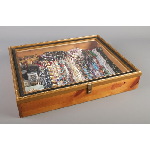 40 - A tabletop bijouterie cabinet containing a large collection of costume jewellery including polished ... 