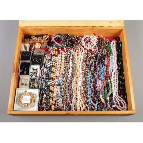 40 - A tabletop bijouterie cabinet containing a large collection of costume jewellery including polished ... 