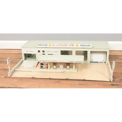 270 - A scratch built petrol station with pumps and forecourt and Chrysler car garage.