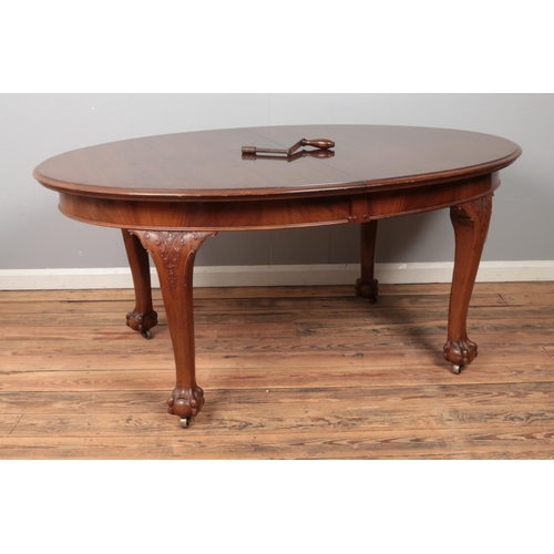 533 - A large oval mahogany extending dining table, with carved ball and claw feet raised on casters. Heig... 