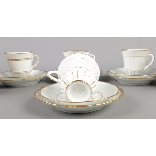 94 - A twenty-four piece Bing and Grondahl teacup, saucer and side plate set, in white with gilt decorati... 