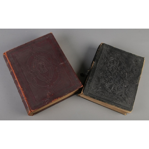 26 - Two leather bound family bibles. Both with monochrome plates.