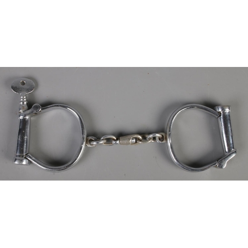 33 - A pair of antique Dowler police handcuffs with key.