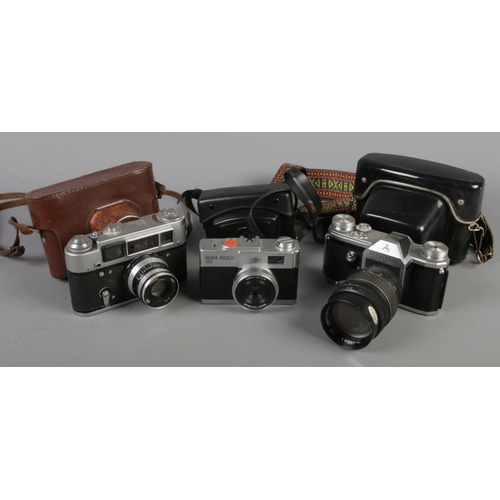 49 - Three cameras. Including Pentacon FM, Fed 4 and Agfa Isoly 100. All with cases.