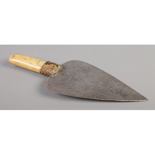 71 - An antique African ceremonial knife with bone and snakeskin handle and with hammered decoration to b... 