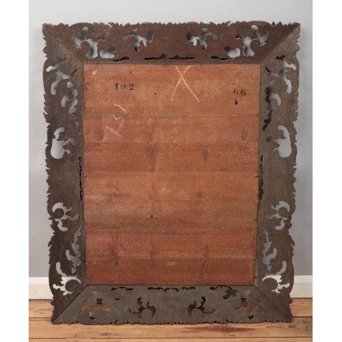 116 - A large French oak mirror with carved and pierced border. 160cm x 95cm.