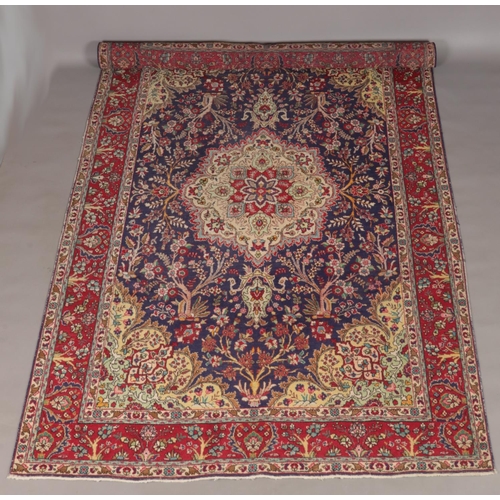 119 - A rich blue ground Persian Tabriz carpet with bespoke floral medallion design. 300cm x 198cm.