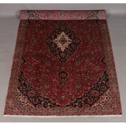 120 - A washed red ground fine woven Persian Kashan carpet with floral medallion design. 335cm x 200cm.