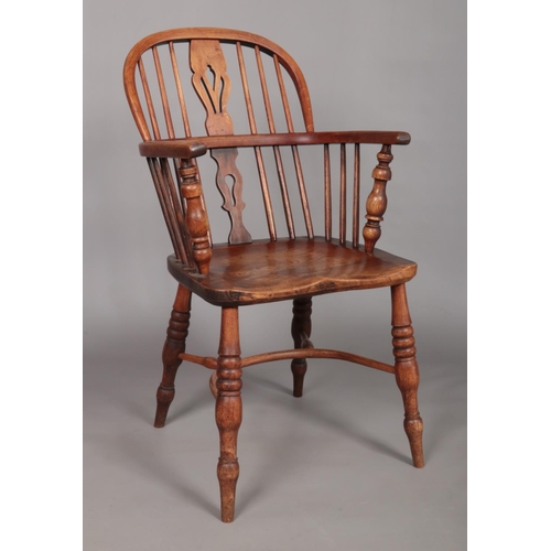 125 - A 19th century Windsor arm chair with pierced slat and crinoline stretcher.