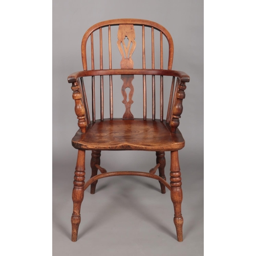 125 - A 19th century Windsor arm chair with pierced slat and crinoline stretcher.