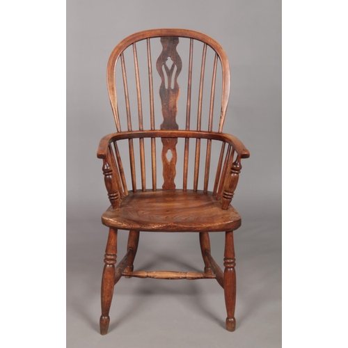 126 - A 19th century ash/elm Windsor arm chair with pierced slat.