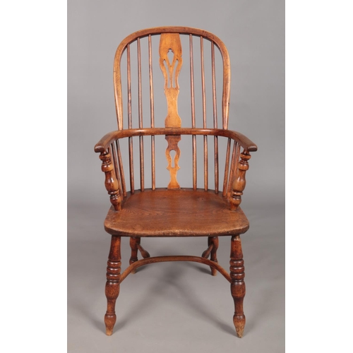 128 - A 19th century ash/elm Windsor arm chair with crinoline stretcher and pierced slat.