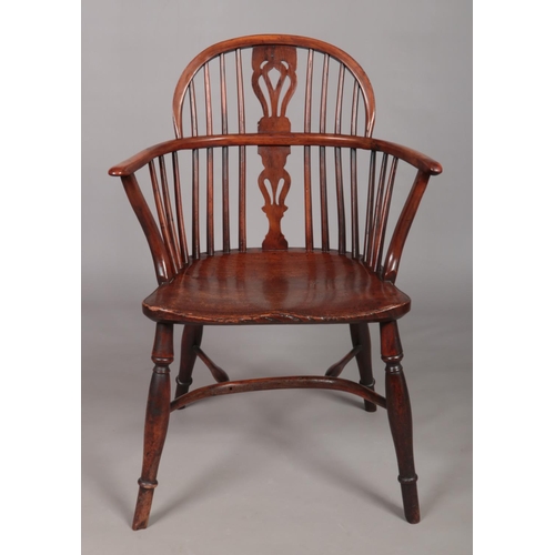 130 - A 19th century ash/elm and yew wood Windsor arm chair with crinoline stretcher and pierced slat. Tot... 