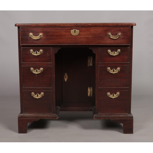 132 - A Georgian mahogany knee hole desk. Height 79cm, Width 84cm, Depth 51cm.