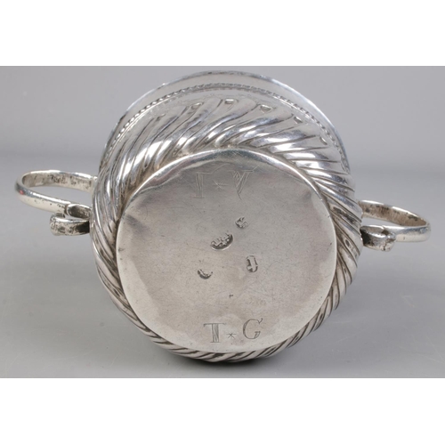 34 - A William III silver porringer with twin S-scroll handles. Initialled IV and TG to base. Assayed Lon... 