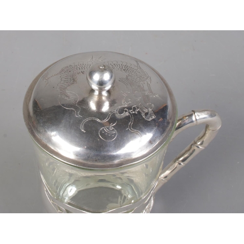 49 - A Chinese pierced silver cup holder and lid. Decorated with a dragon and having bamboo effect handle... 