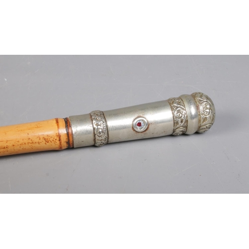 56 - An antique bamboo sword stick. With white metal pommel and collar. The pommel set with two small rub... 