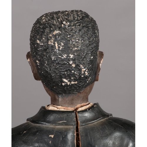 77 - A large carved wooden blackamoor and polychrome statue of a young boy dressed in ragged jacket and s... 