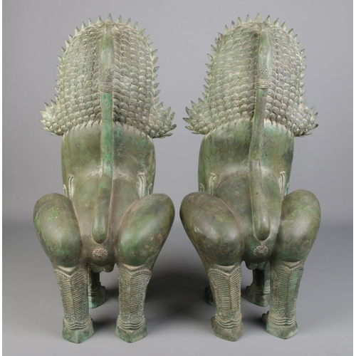 79 - A large pair of bronze Khmer style sculptures modelled as temple lions. Height 60cm.