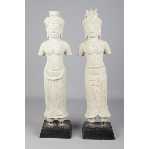 80 - After antiquity, a pair of Khmer style carved stone sculptures, raised on wood plinths. Heights 62cm... 