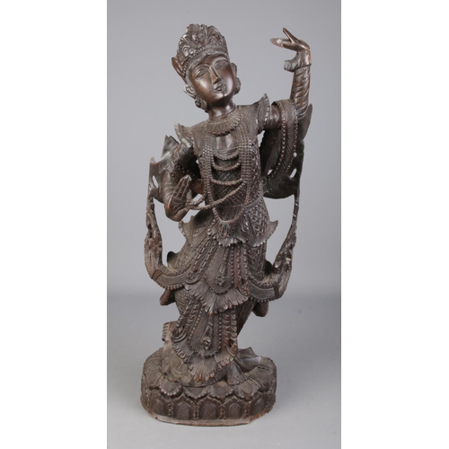 81 - A large carved wooden figure formed as a Burmese/Thai dancer. Height 63cm.