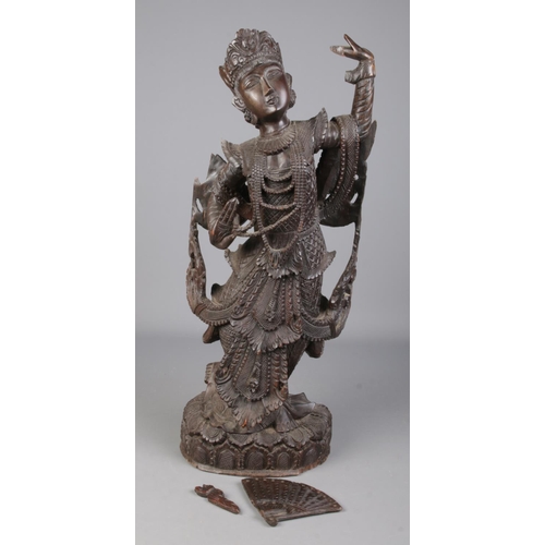 81 - A large carved wooden figure formed as a Burmese/Thai dancer. Height 63cm.