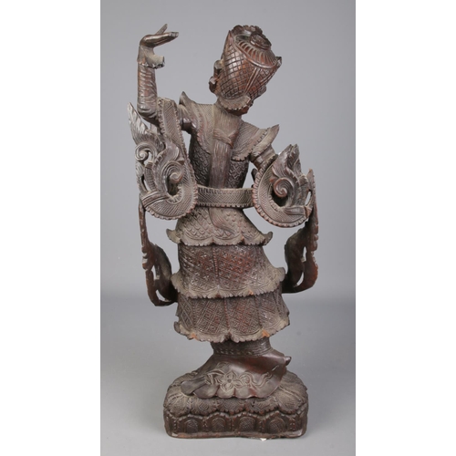 81 - A large carved wooden figure formed as a Burmese/Thai dancer. Height 63cm.