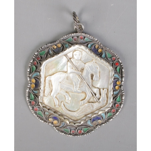 87 - A 19th century Russian silver pendant. With central carved mother of pearl panel depicting a warrior... 