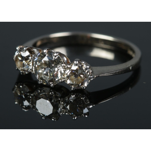 90 - An 18ct white gold three stone diamond ring. Size K. 2.64g.