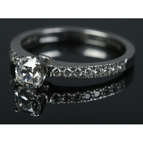 92 - A Tiffany & Co Harmony platinum and diamond ring. The brilliant cut centre stone in claw setting fla... 