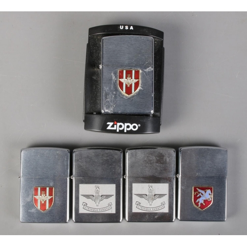 215 - Five modern Zippo lighters bearing Parachute Regiment insignias.