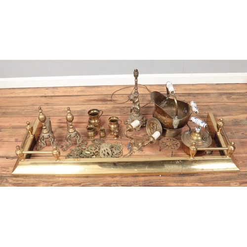 324 - A box of brasswares. Includes extending fire fender, table lamp, horse brasses etc.