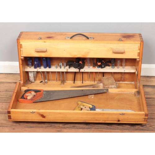 336 - A hinged pine tool case, with contents of tools. To include saws, mallet, drill bits, files etc.