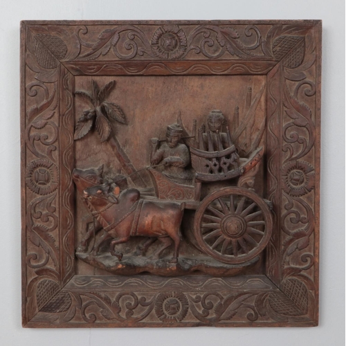 356 - A carved wooden plaque depicting a cart with figures pulled by buffalo. Height: 45 cm, Width: 44cm.