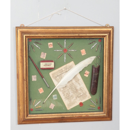 369 - A gilt framed diorama, with contents including Richard Prescott, writing instruments and stamps etc.... 