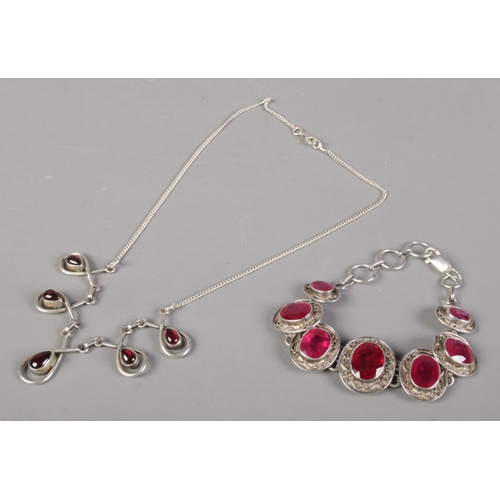 411 - A silver bracelet set with ruby coloured stones, together with a similar pendant necklace. Total wei... 